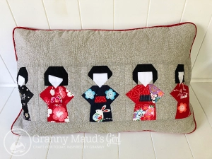 Cushion featuring patchwork kokeshi dolls